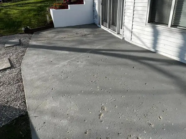 Cracked outdoor walkway with pitted surface before coating