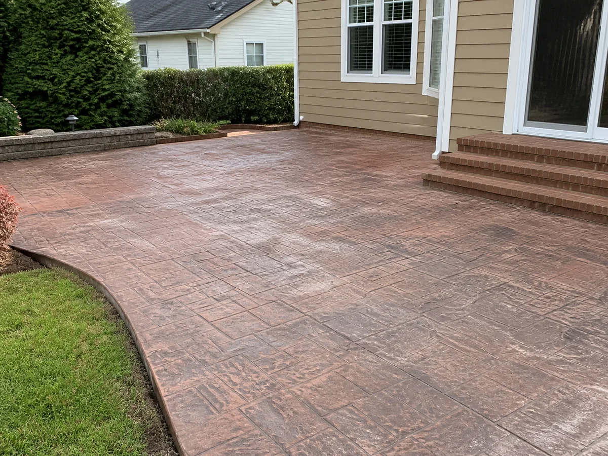 Illustrative faded and chalky red stamped patio before restoration