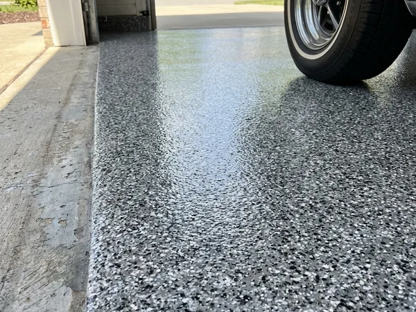 Black and white flake garage floor coating at garage entrance by Panther Coatings